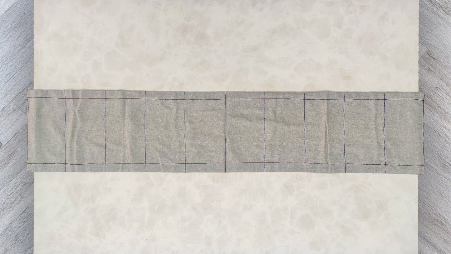 Hand embroidered with maroon and blue cotton thread, this handcrafted table runner is designed to be double sided.