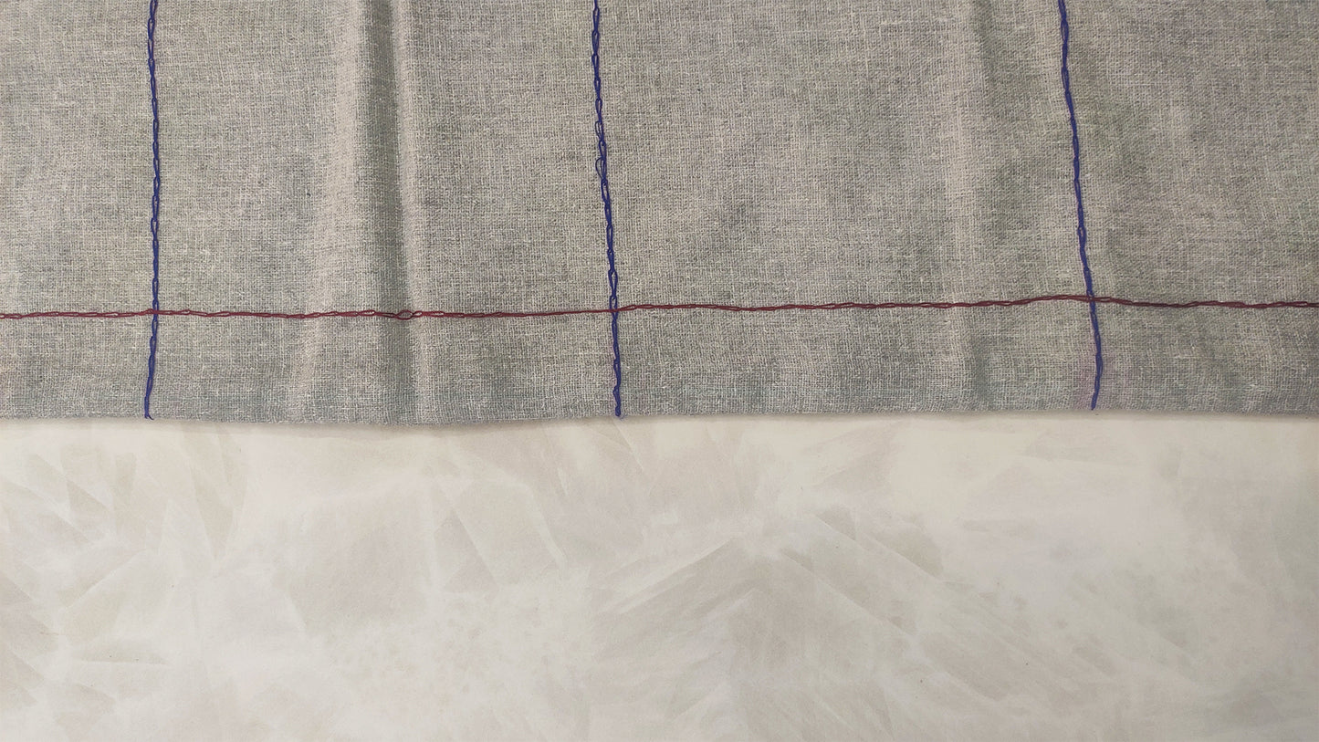 Hand embroidered with maroon and blue cotton thread, this handcrafted table runner is designed to be double sided.