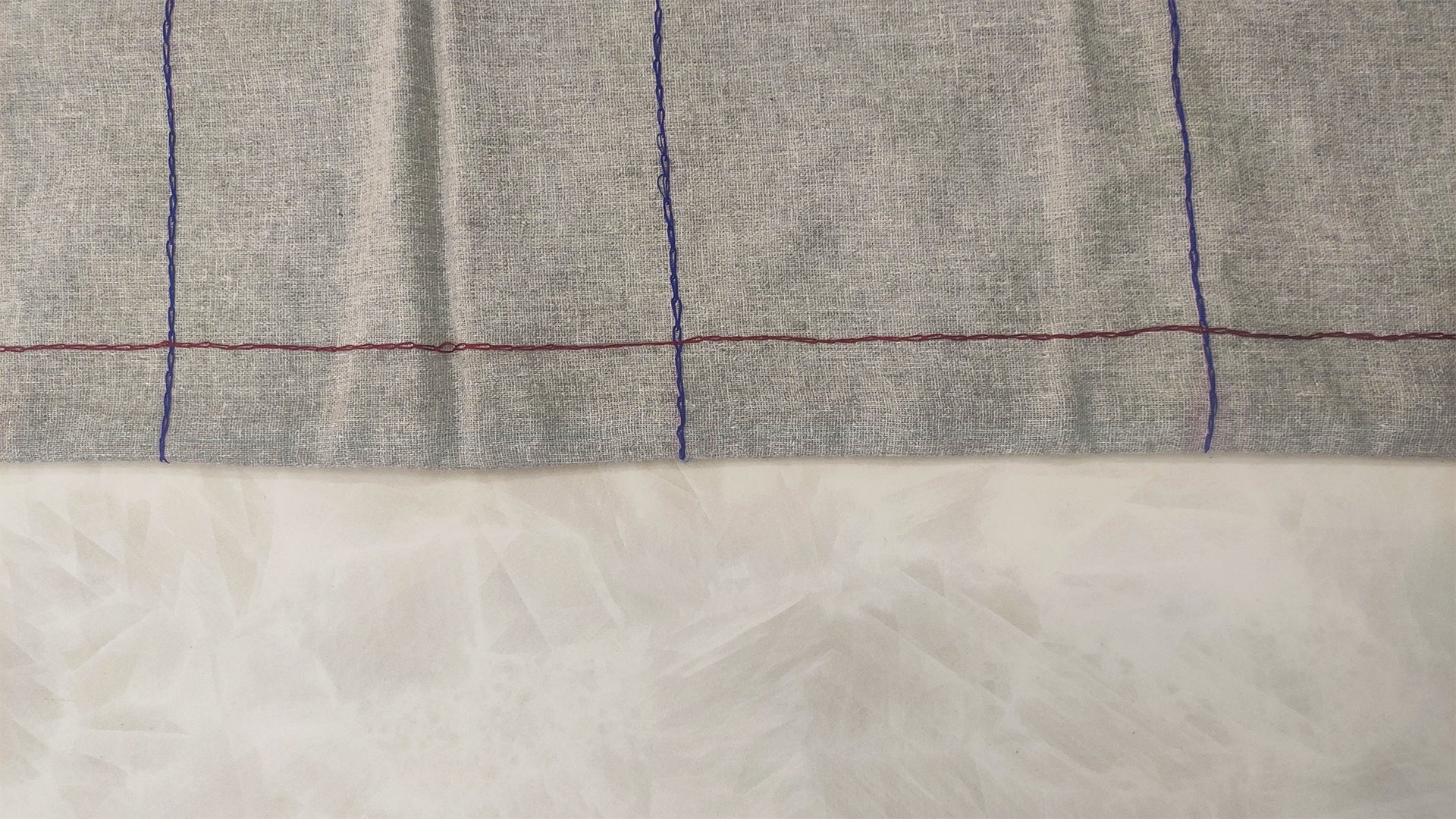 Hand embroidered with maroon and blue cotton thread, this handcrafted table runner is designed to be double sided.