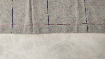 Hand embroidered with maroon and blue cotton thread, this handcrafted table runner is designed to be double sided.