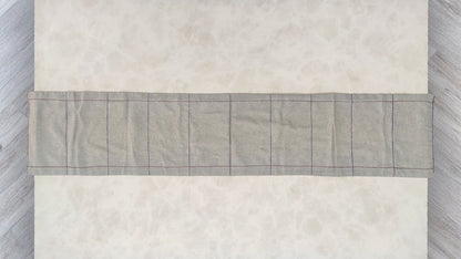 Hand embroidered with maroon and blue cotton thread, this handcrafted table runner is designed to be double sided.