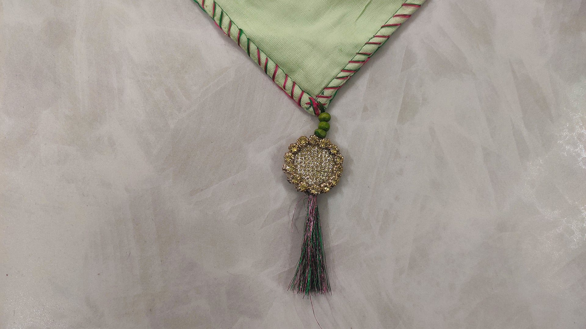 Hand embroidered with pink and green cotton thread with golden zari, this handcrafted table runner is paired with set of 6 lap napkins. Designed to be double sided