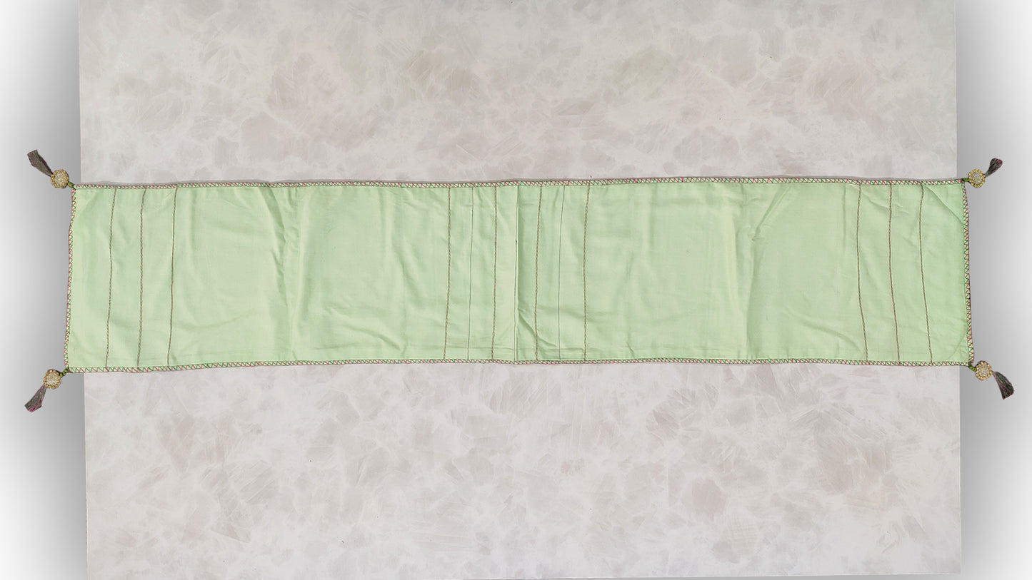 Hand embroidered with pink and green cotton thread with golden zari, this handcrafted table runner is paired with set of 6 lap napkins. Designed to be double sided.
