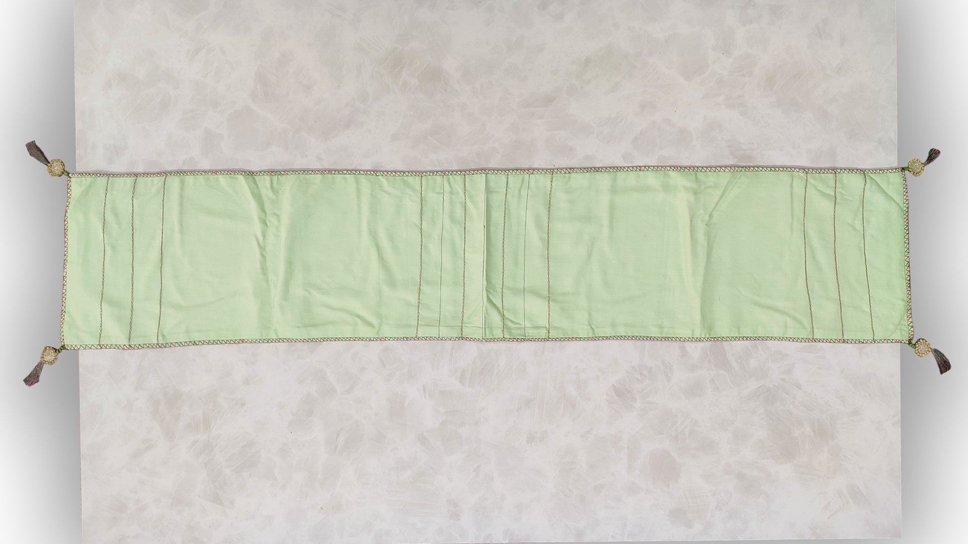 Hand embroidered with pink and green cotton thread with golden zari, this handcrafted table runner is paired with set of 6 lap napkins. Designed to be double sided.