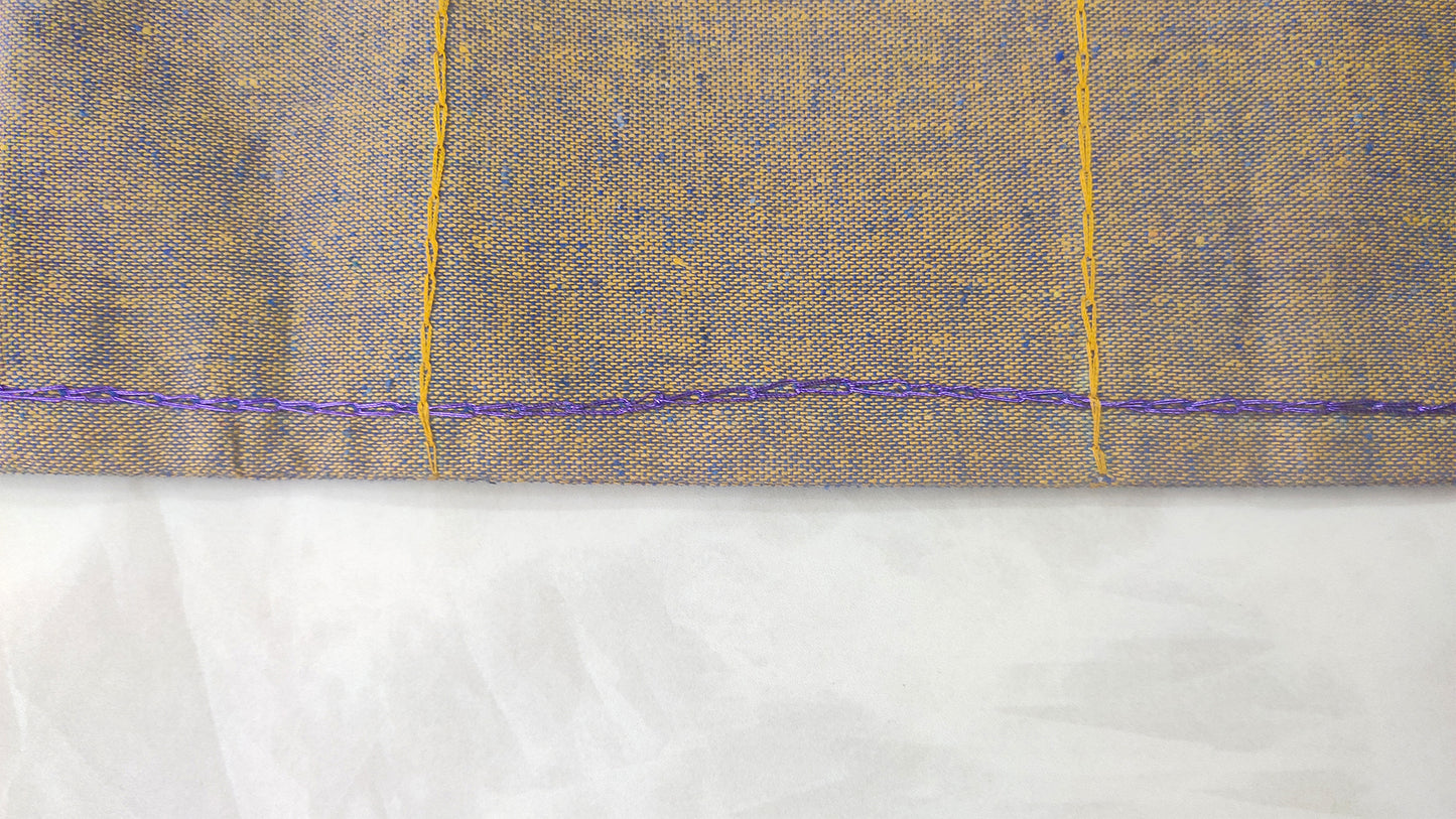 Hand embroidered with yellow and blue cotton thread, this handcrafted table runner is designed to be double sided.