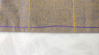 Hand embroidered with yellow and blue cotton thread, this handcrafted table runner is designed to be double sided.
