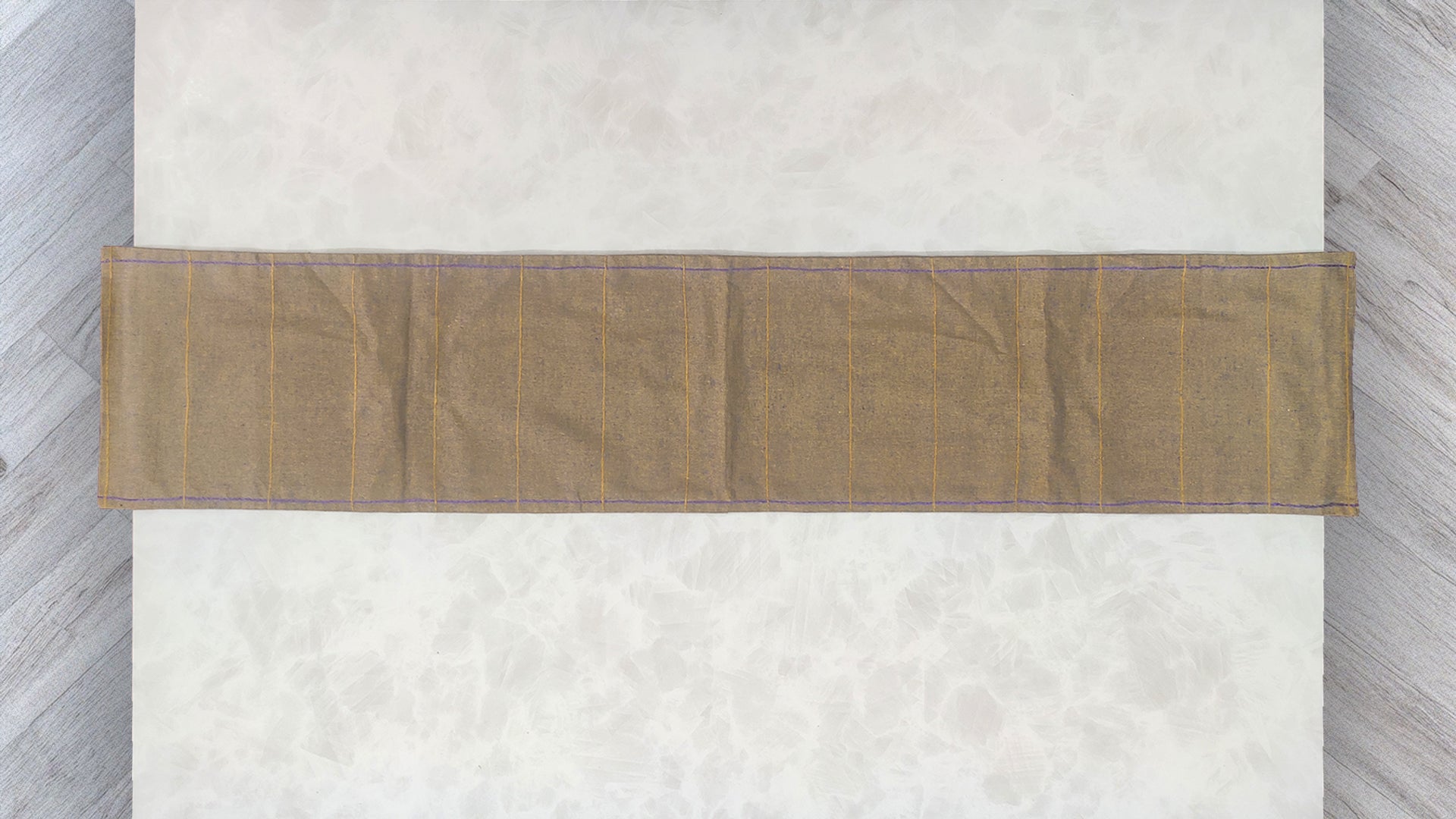 Hand embroidered with yellow and blue cotton thread, this handcrafted table runner is designed to be double sided.