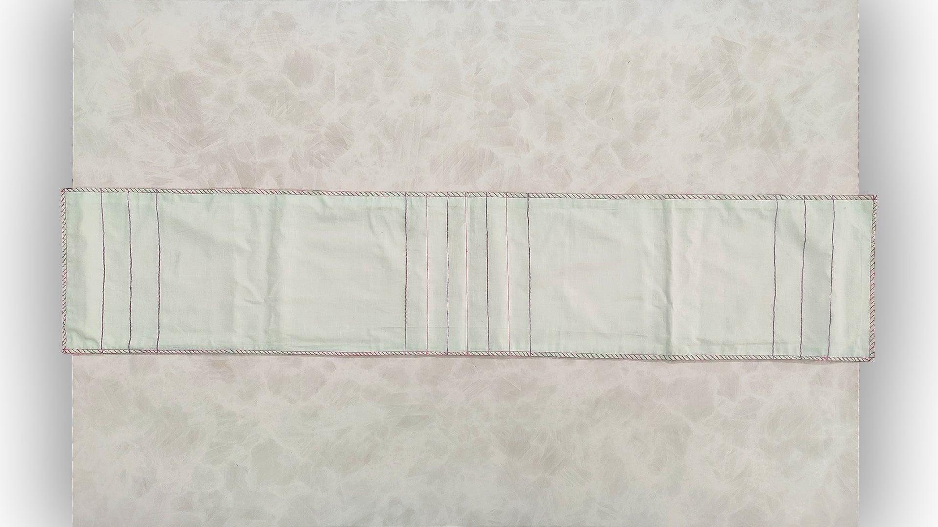 Hand embroidered with pink and purple cotton thread with golden zari, this handcrafted table runner is paired with set of 6 lap napkins. Designed to be double sided.