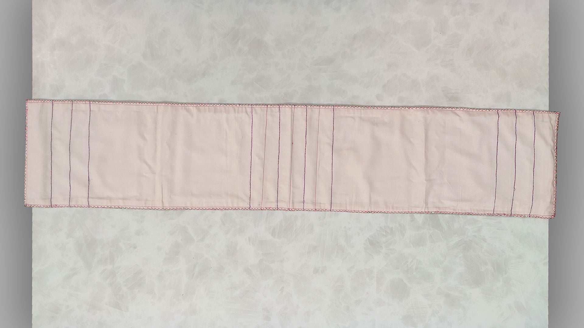 Hand embroidered with pink and purple cotton thread with golden zari, this handcrafted table runner is paired with set of 6 lap napkins. Designed to be double sided.