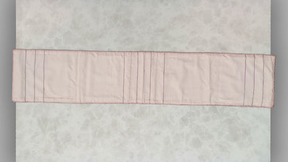 Hand embroidered with pink and purple cotton thread with golden zari, this handcrafted table runner is paired with set of 6 lap napkins. Designed to be double sided.
